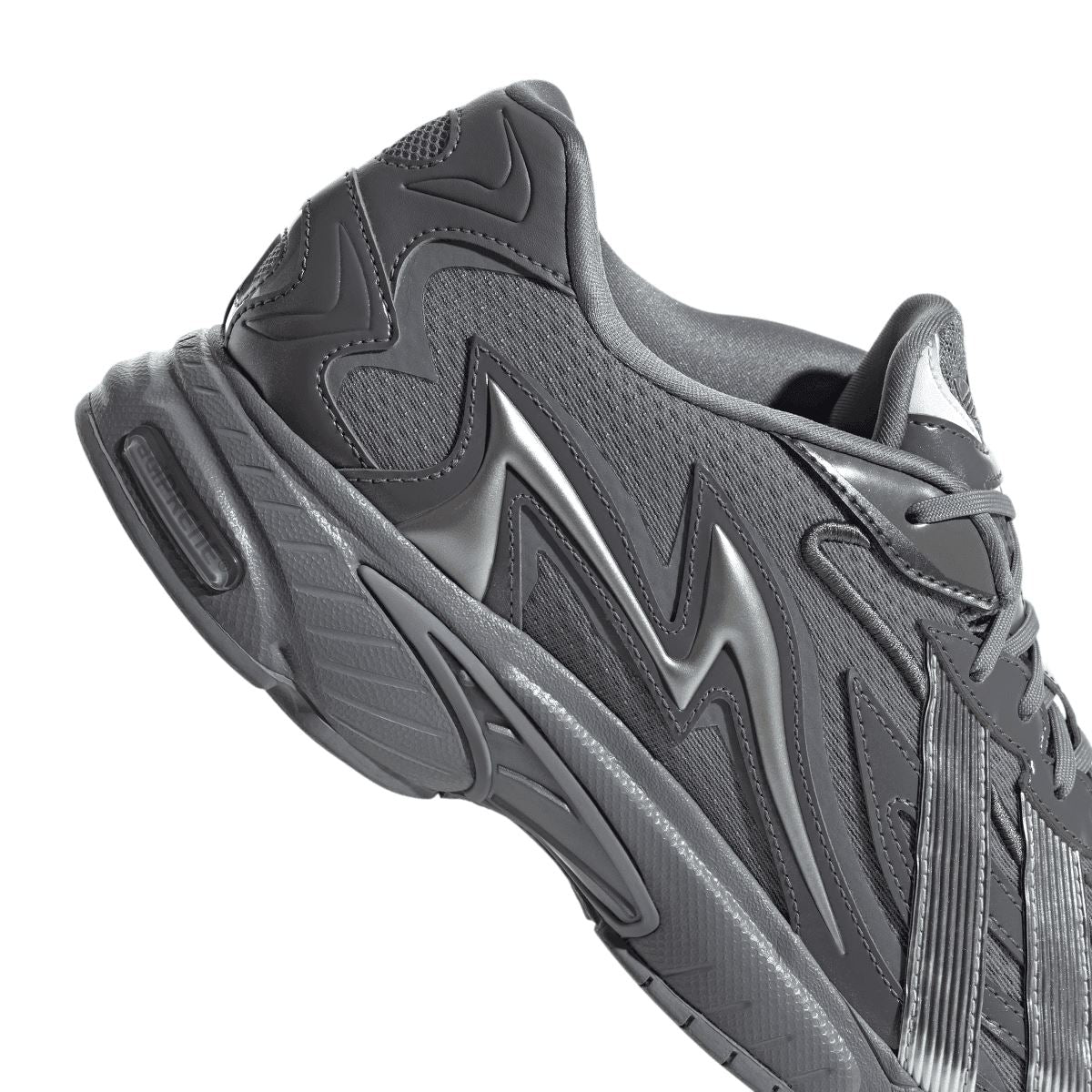 Grey adidas trainer close-up side view with sculpted sole and stripe pattern
