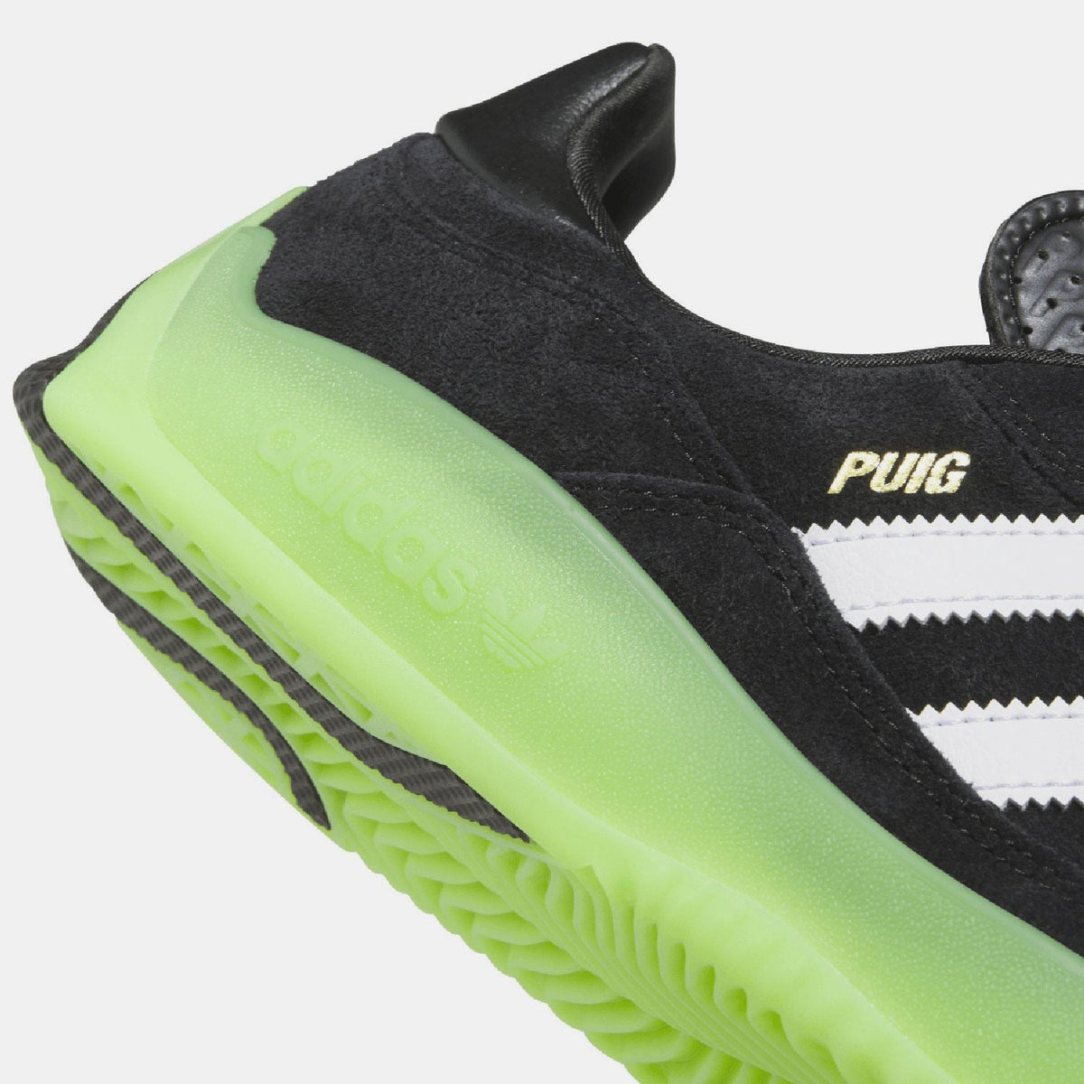 Close-up of black upper and neon green translucent midsole on trainers