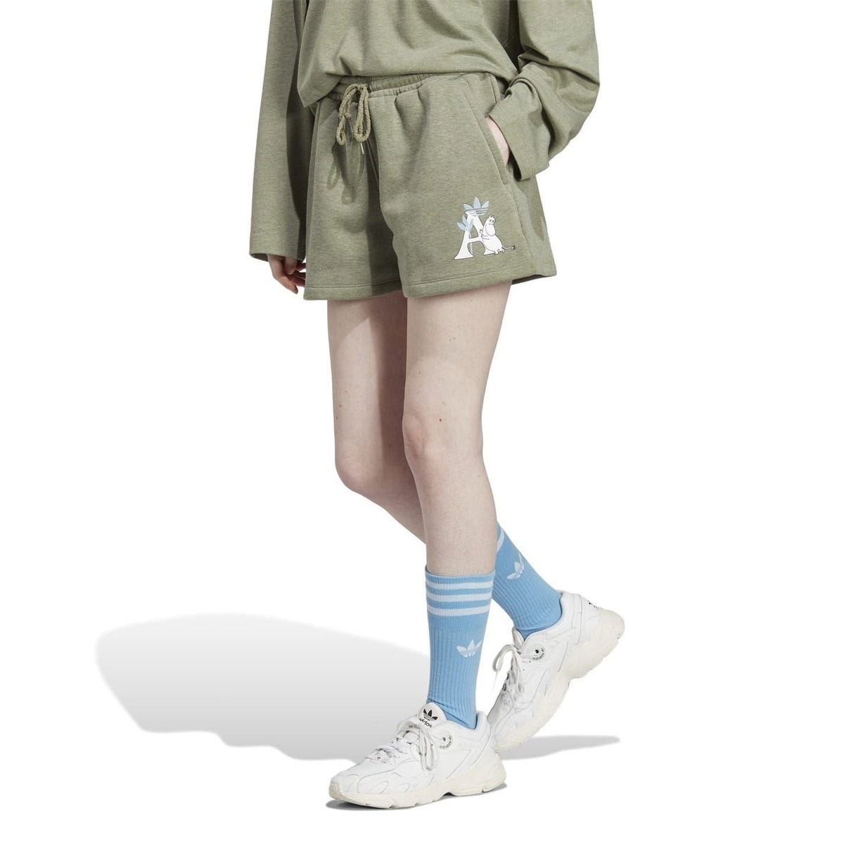 Green drawstring sweat shorts with Moomin graphic, side view on a model