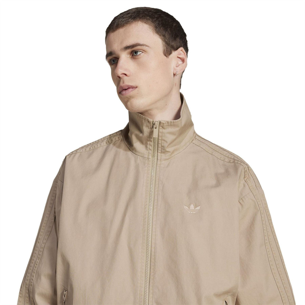 Beige track jacket with stand collar, full zipper, and adidas trefoil on chest