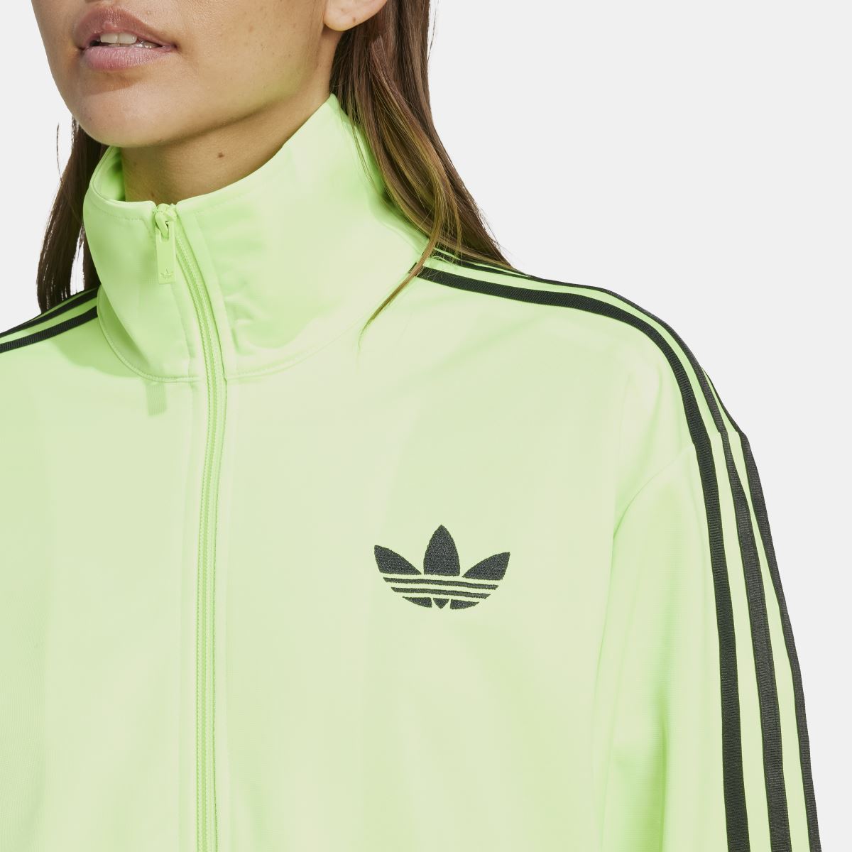 Lime green track top with black trefoil emblem and stand collar zip front