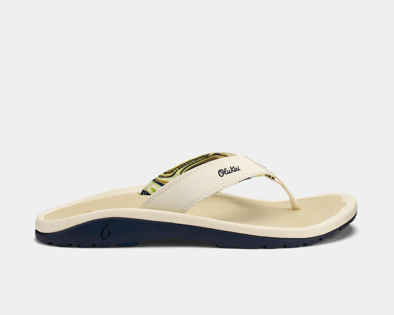 Cream thong sandals with dark navy insole and green pattern strap