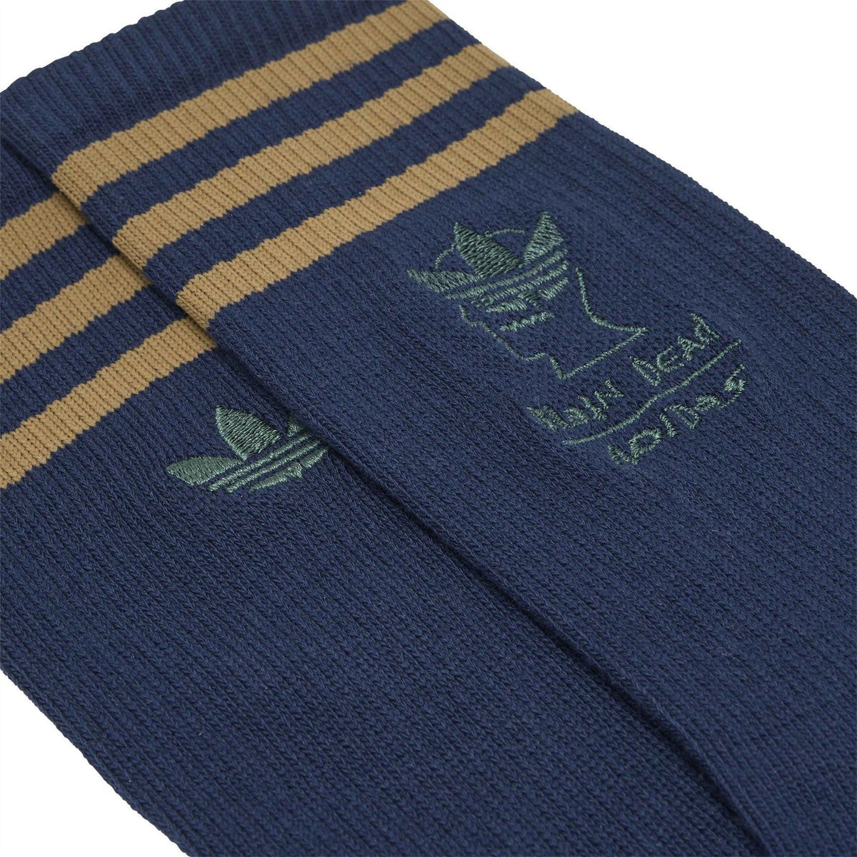 Folded navy crew socks with tan-and-gold striped cuff, green trefoil and Brain Dead graphic