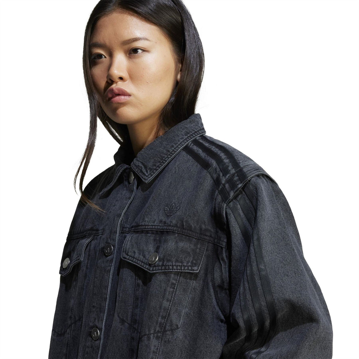Black denim shirt jacket close-up with chest patch pocket, buttons, and collar