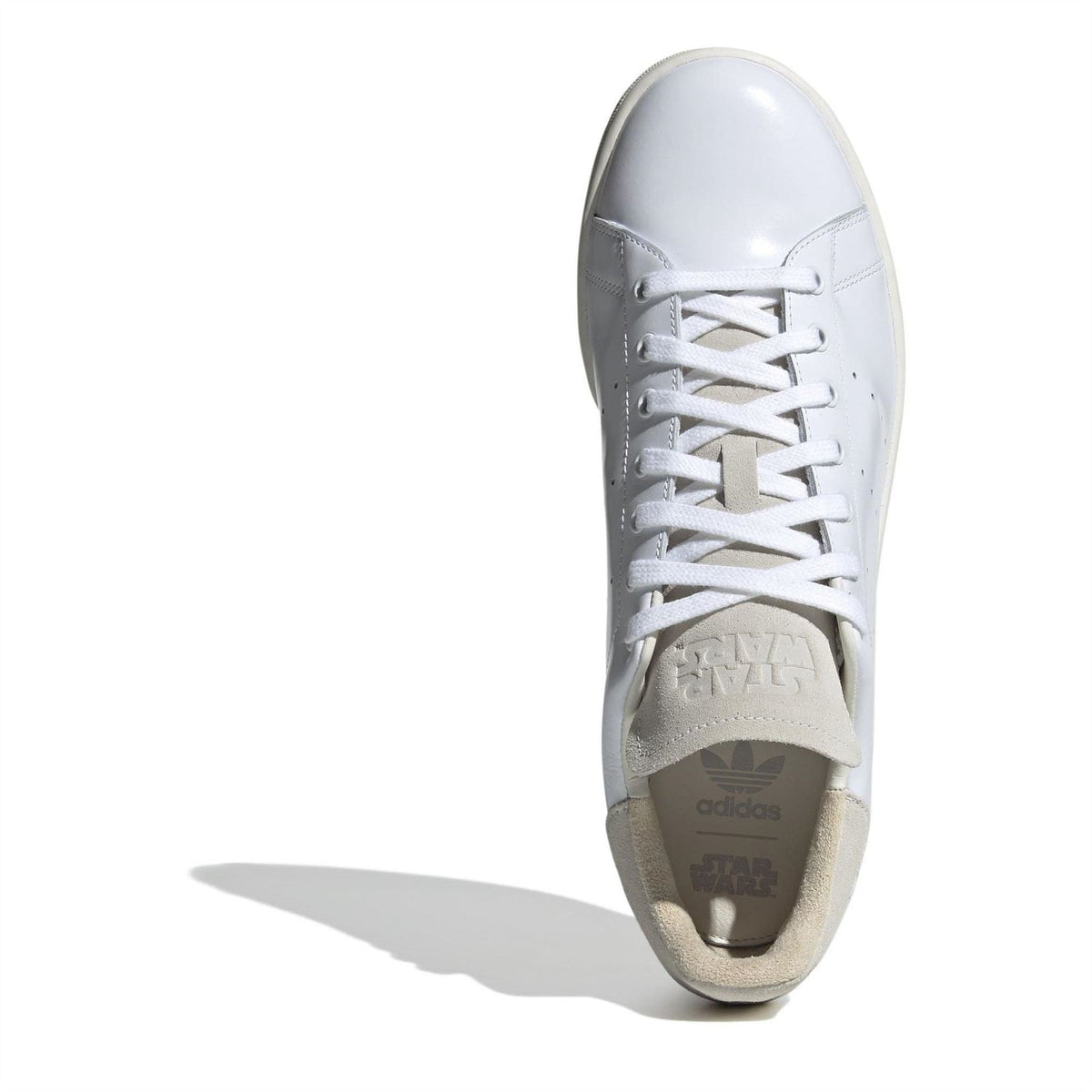 White sneaker toe-and-lace view with beige insole and cushioned heel cup