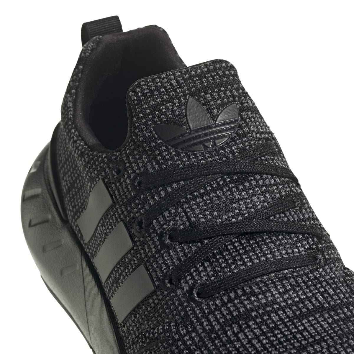 Kids' adidas trainers close-up of heel and side stripes on dark speckled knit