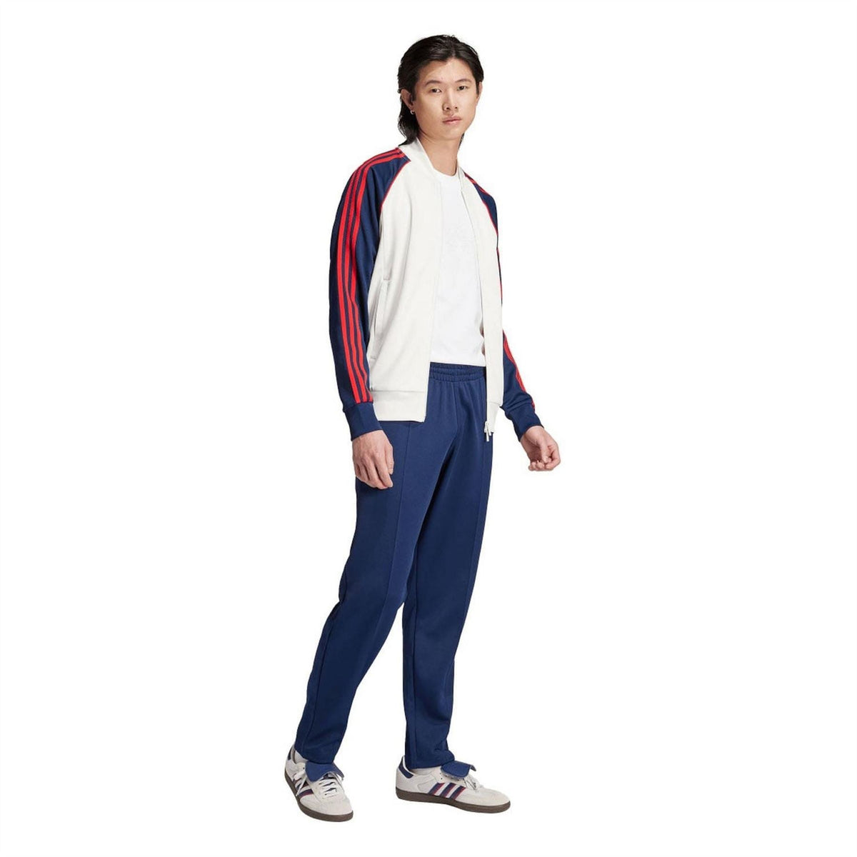 White adidas track jacket with navy/red stripe sleeves, worn with matching navy pants