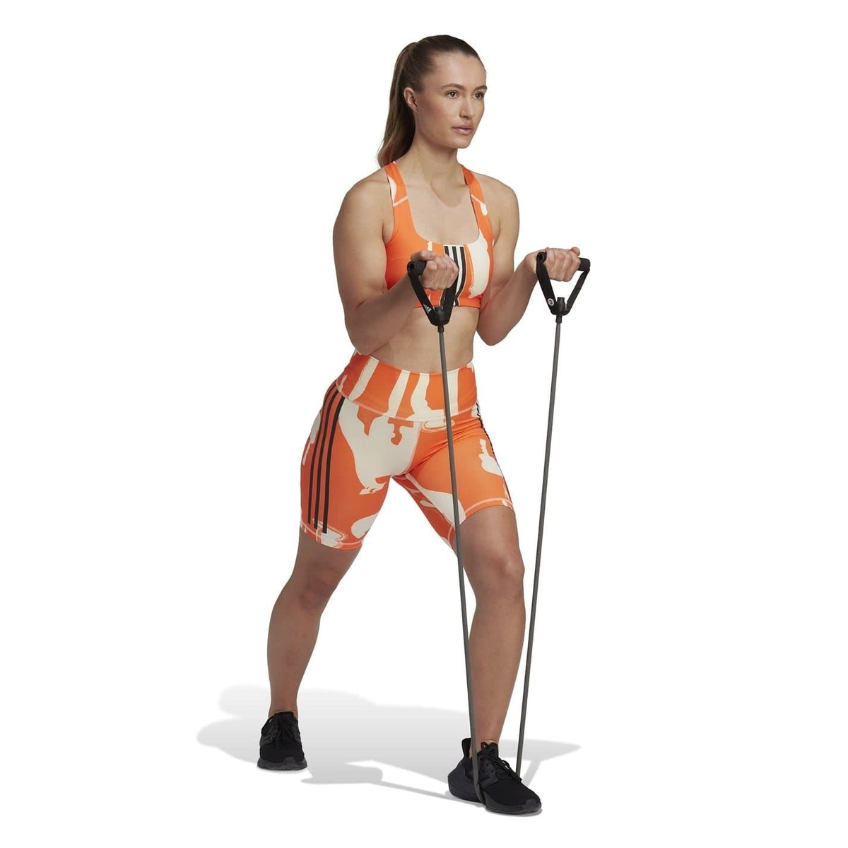Orange and beige graphic cycling shorts on model, snug fit with high-rise waistband