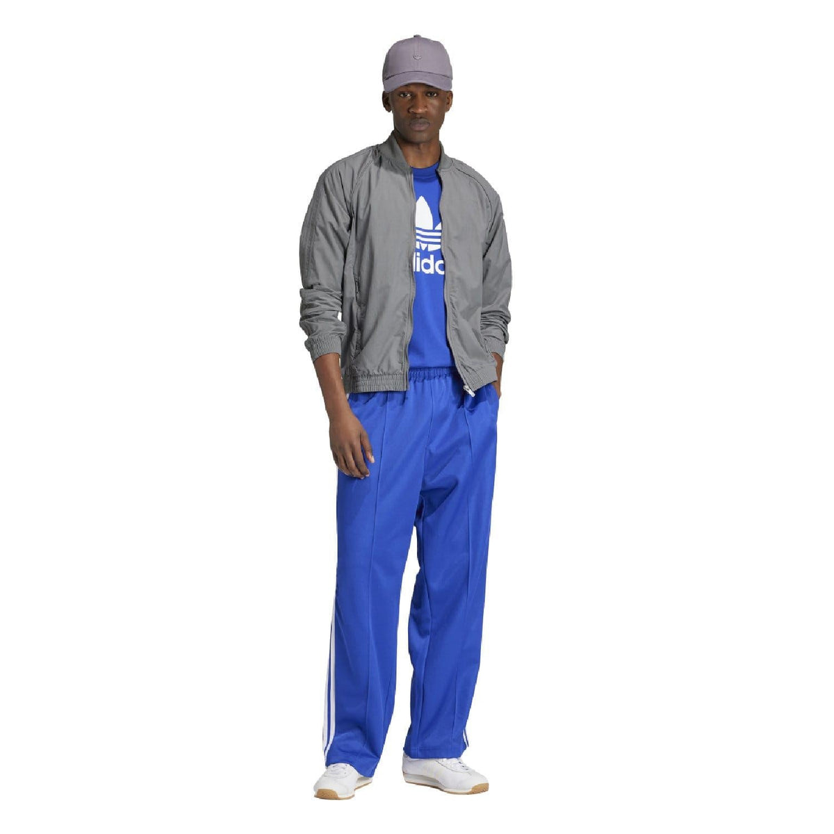 Blue crew-neck t-shirt with white adidas trefoil logo, worn under gray jacket
