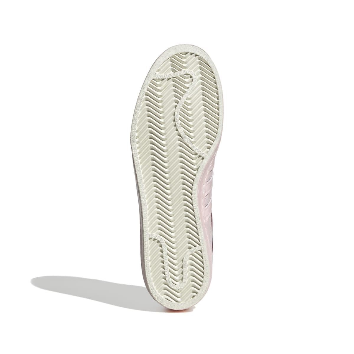 Shoe outsole with textured tread in off-white with pale pink side edge