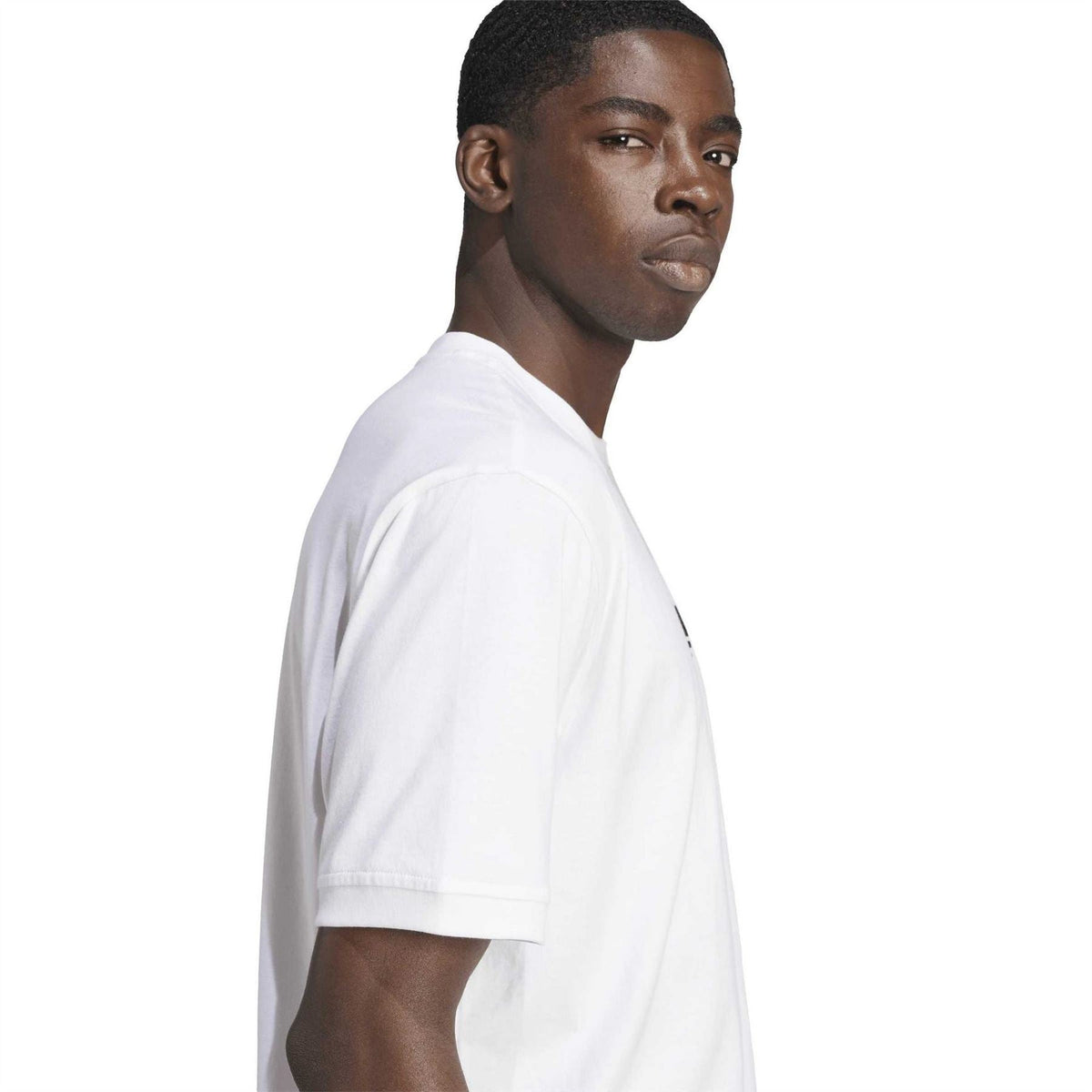 White crew neck T-shirt with short sleeves and black trefoil logo; side view