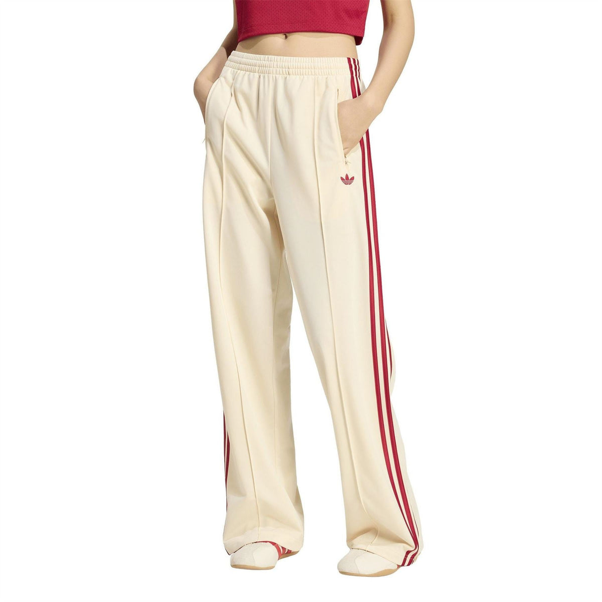Cream jogger pants with red side stripes, elastic waistband, and wide leg