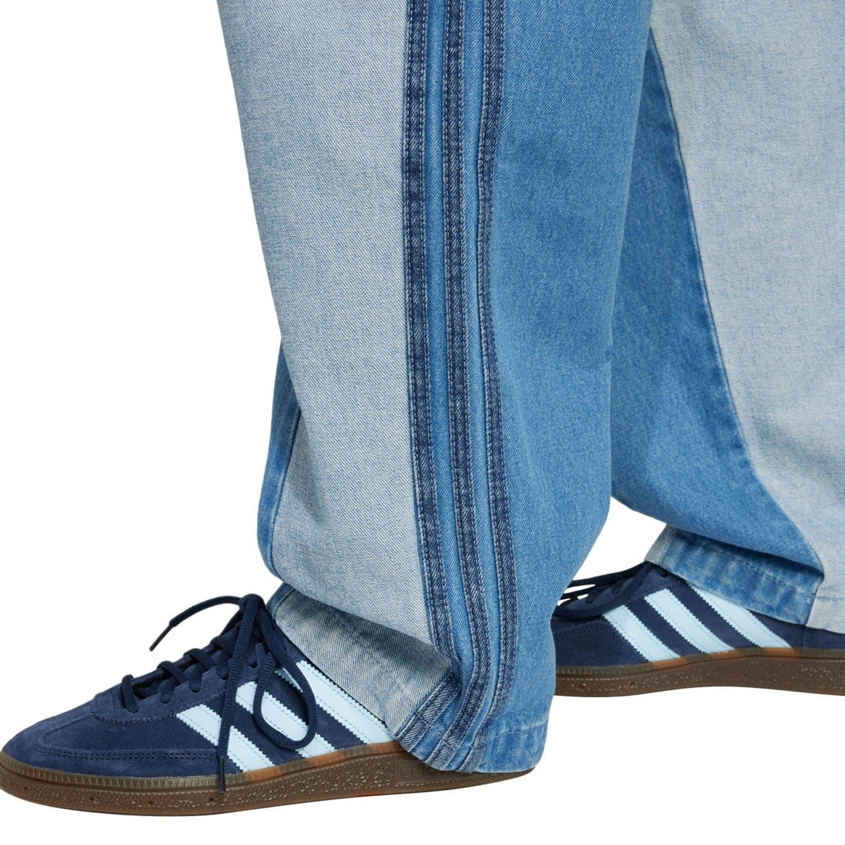 Straight-leg patchwork jeans with vertical contrast stitching along a light-blue side panel.