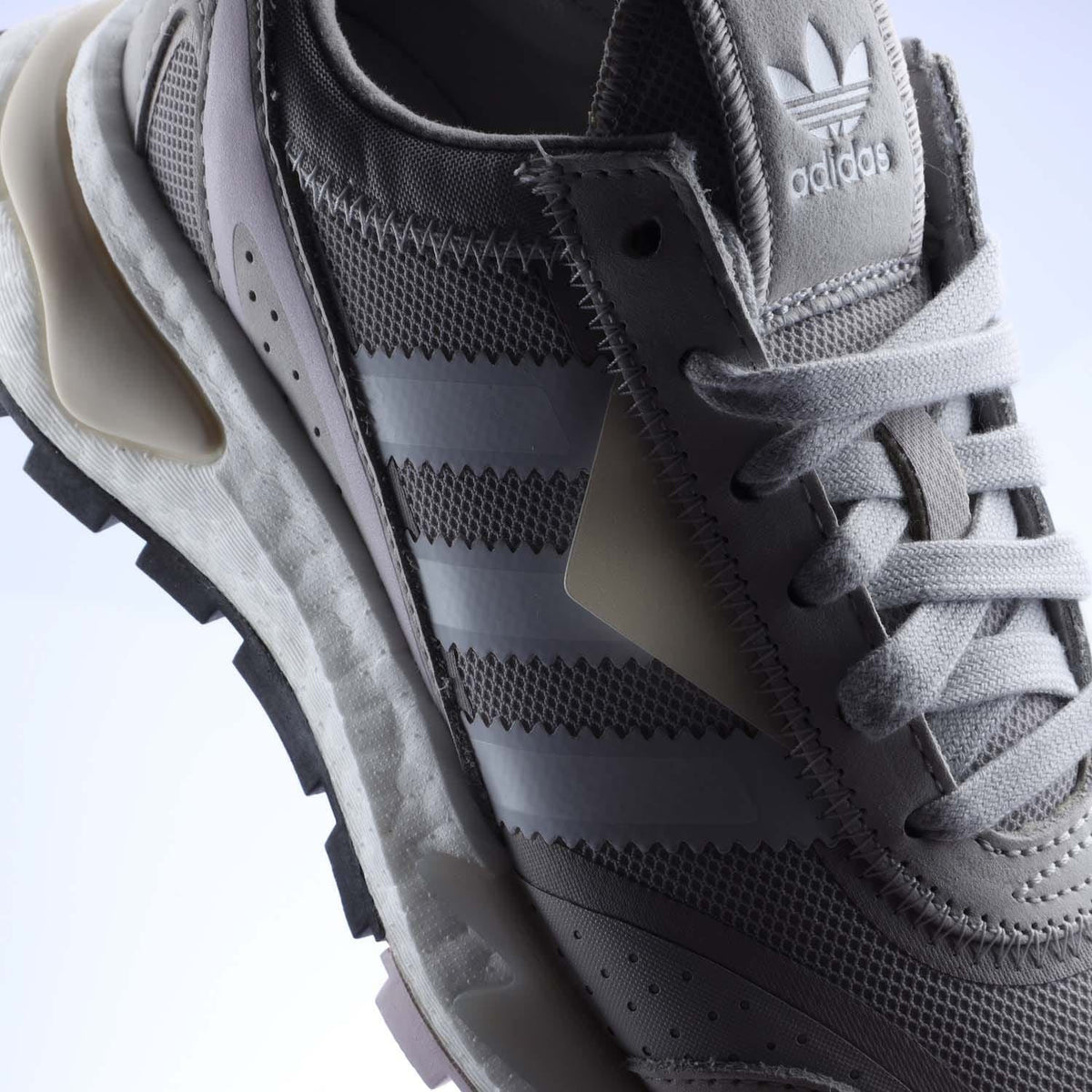 Close-up of grey adidas Originals womens trainer upper with mesh panels and lace-up
