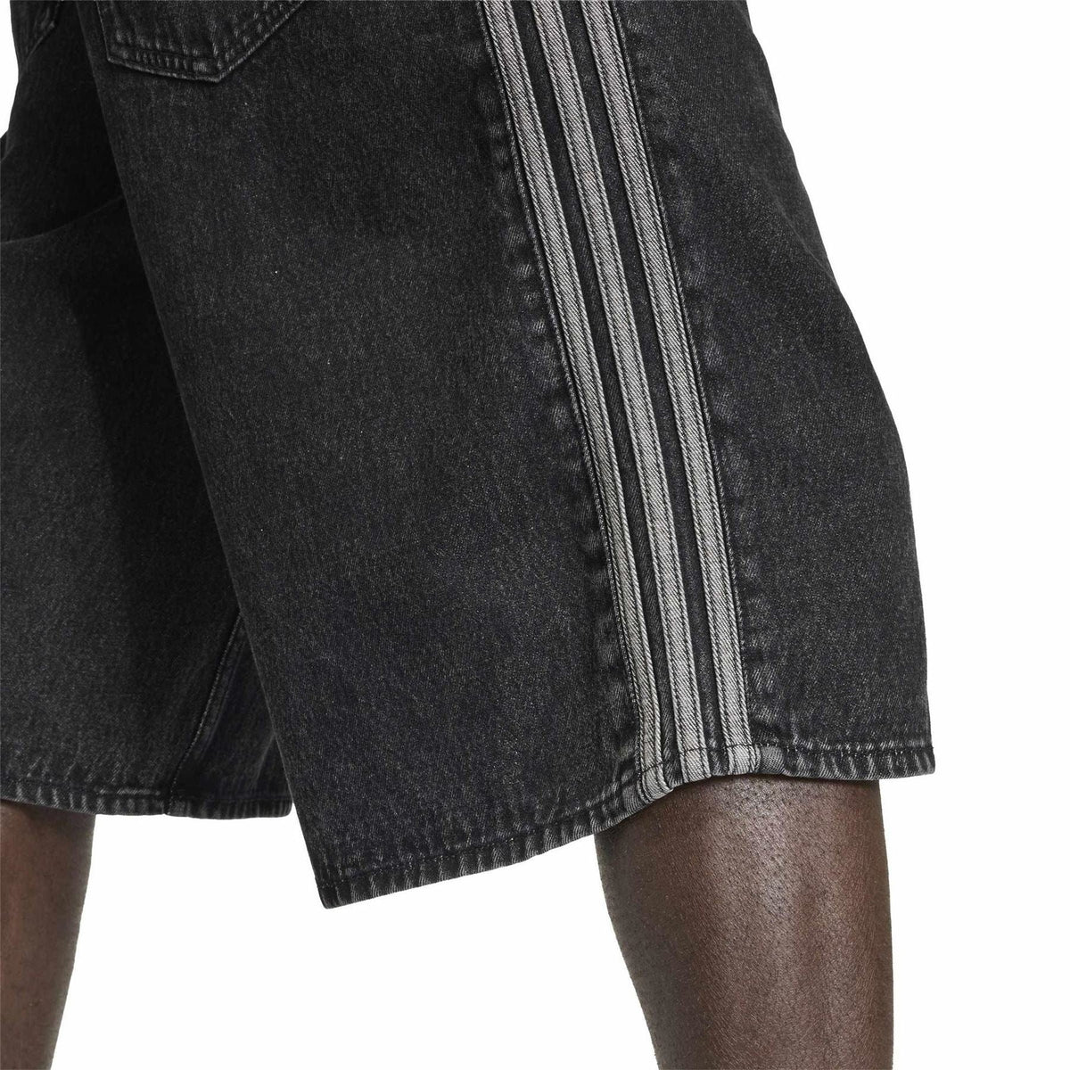 Dark denim shorts hem with layered side stripe panels and visible stitching