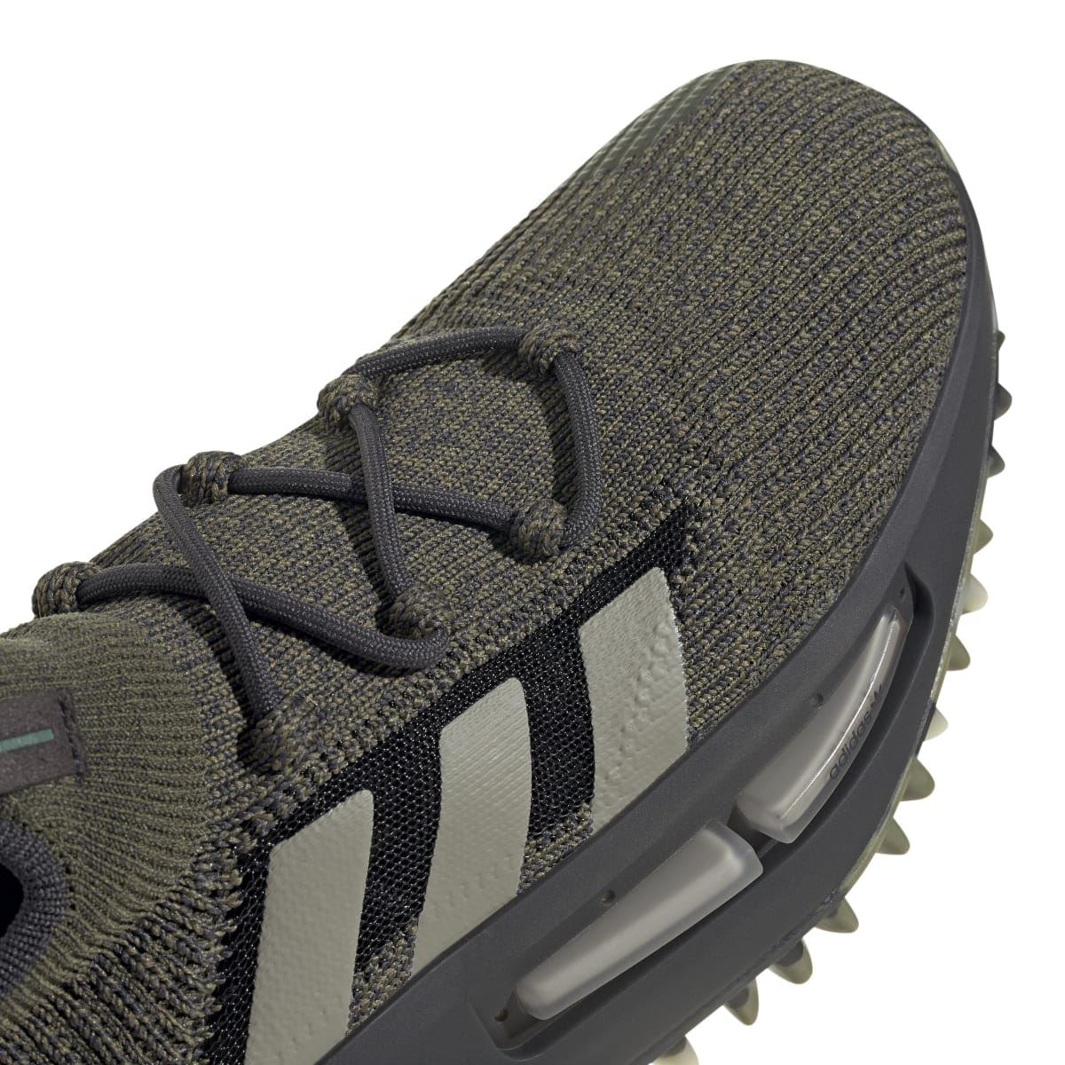Dark olive adidas trainer toe and laces detail with knit texture and gray stripe panel