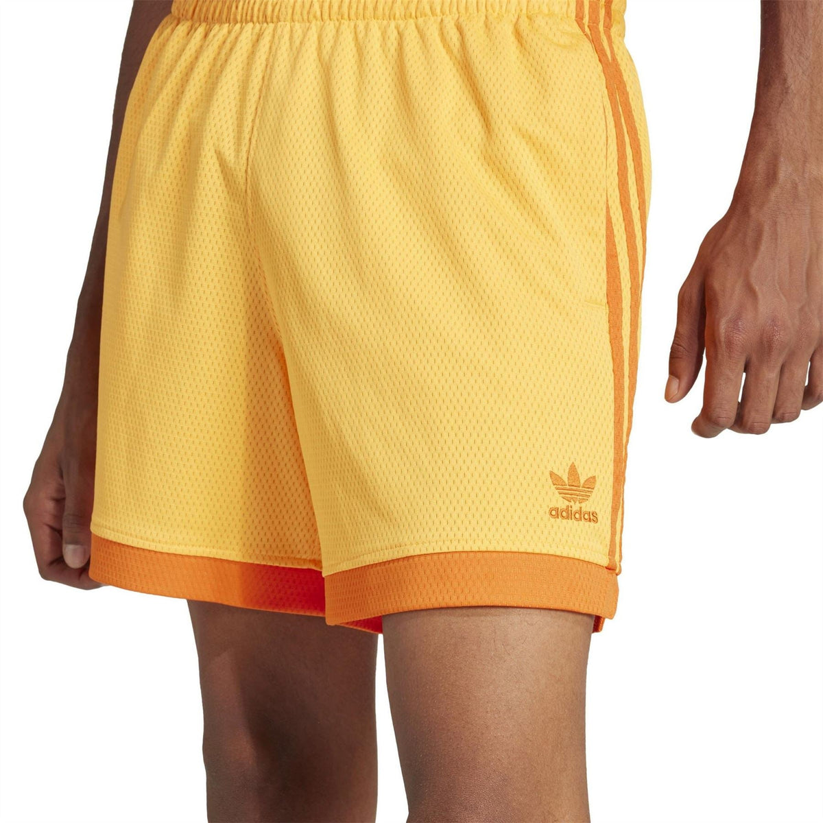 Yellow adidas Originals shorts with orange-trim hem and trefoil logo on leg