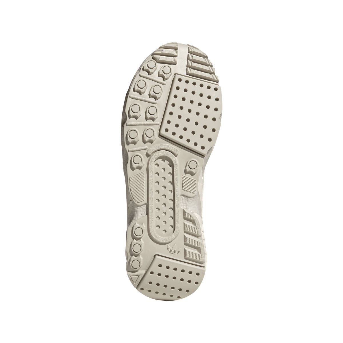 Cream trainer outsole with molded traction pods and circular grip pattern