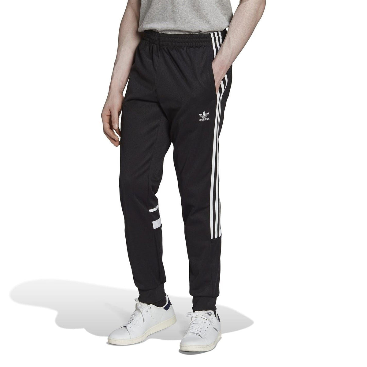 Black slim joggers with adidas logo on thigh, white side three-stripe taping, tapered legs