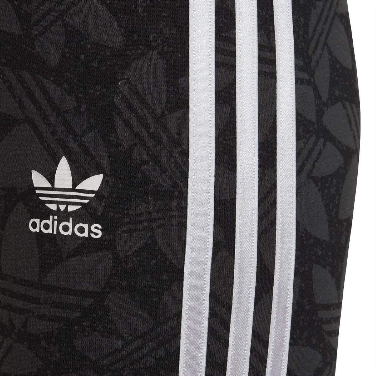 Black adidas leggings close-up with adidas logo and side white triple stripes