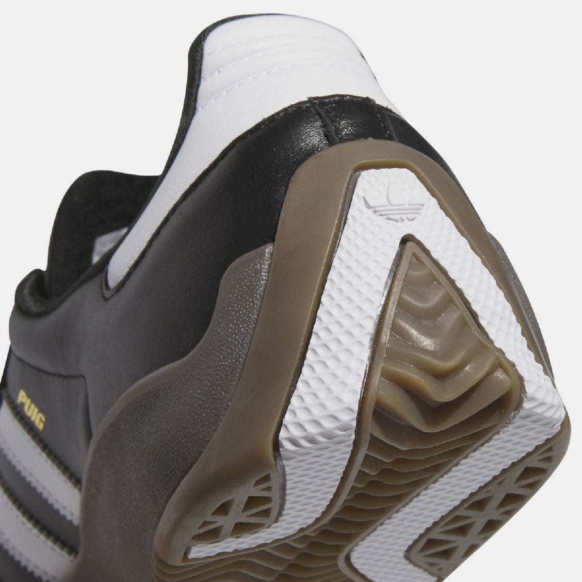 Close-up of black heel and white collar with tan outsole tread detail