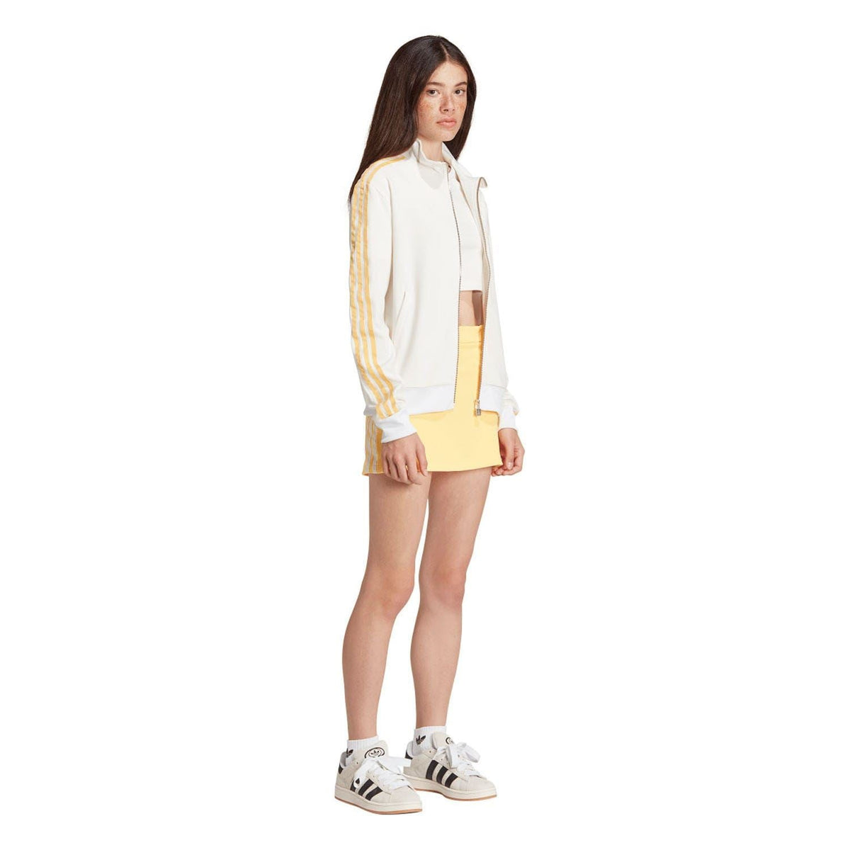 Off-white adidas track top with zip front and gold stripe sleeves, worn with yellow skirt