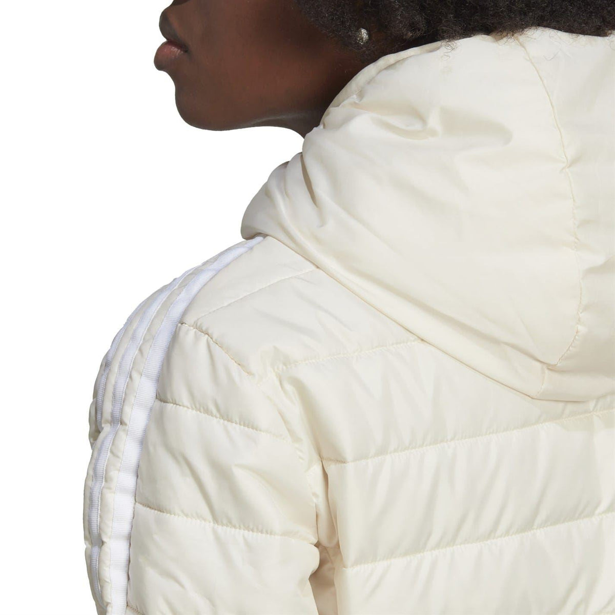 Light cream quilted hood and shoulder close-up on a full-zip puffer jacket.