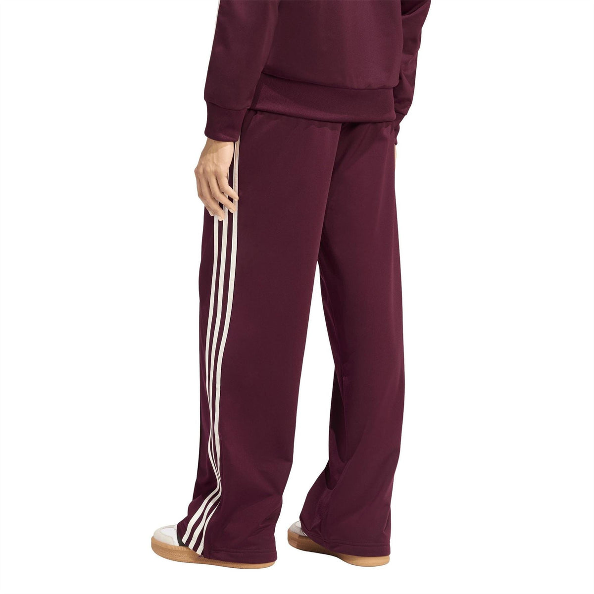 Maroon wide-leg track pants with vertical white side stripe panels and cuffed hem