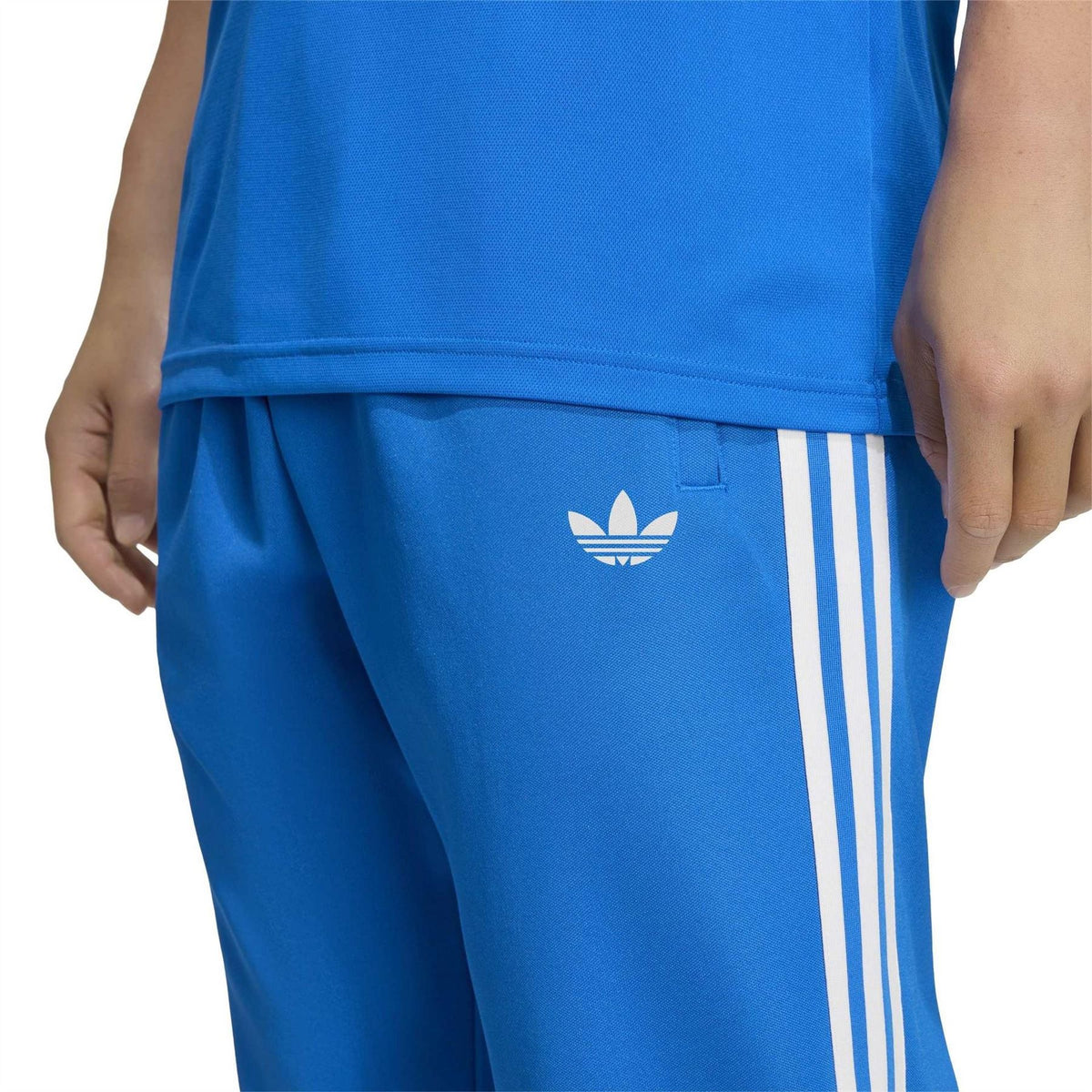 Blue track pants side panel with three white vertical stripes