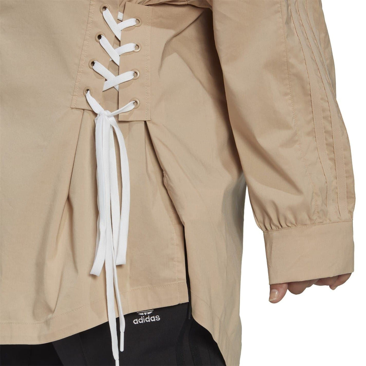Beige long-sleeve shirt close-up of white lace-up side detail and button front