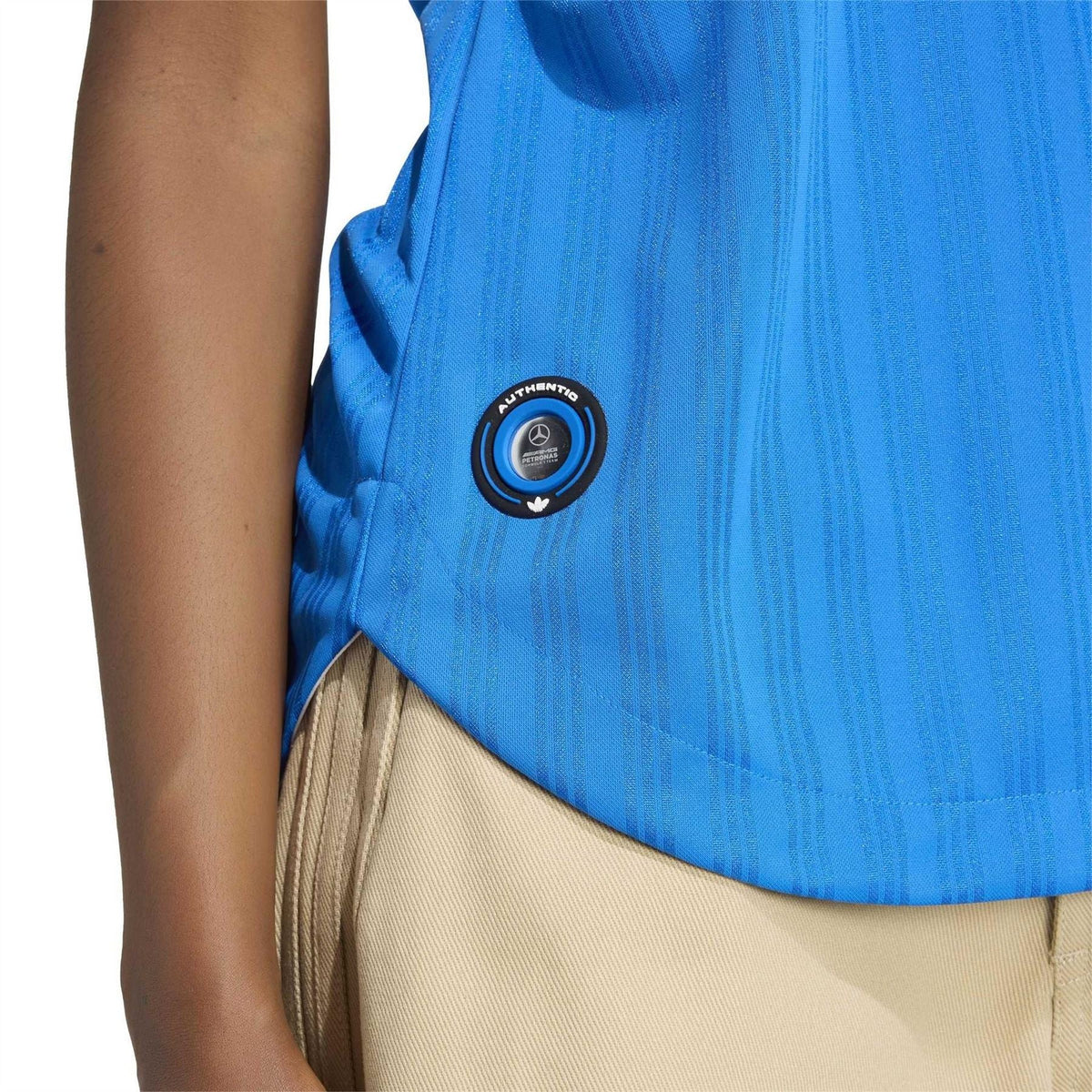 Blue jersey T-shirt with round patch emblem and vertical textured pattern