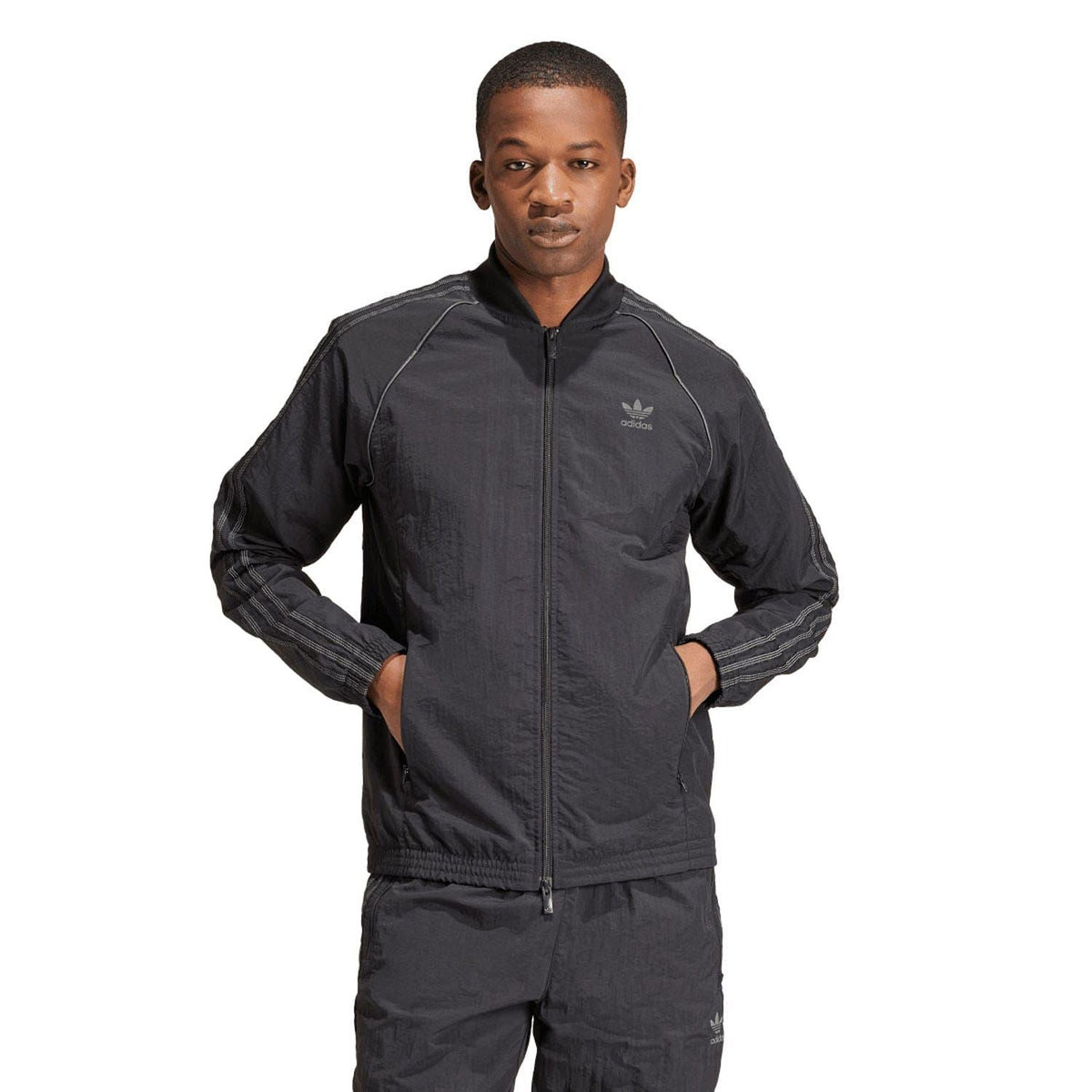 Black adidas Originals track jacket with full zip, stand collar, and logo on chest.