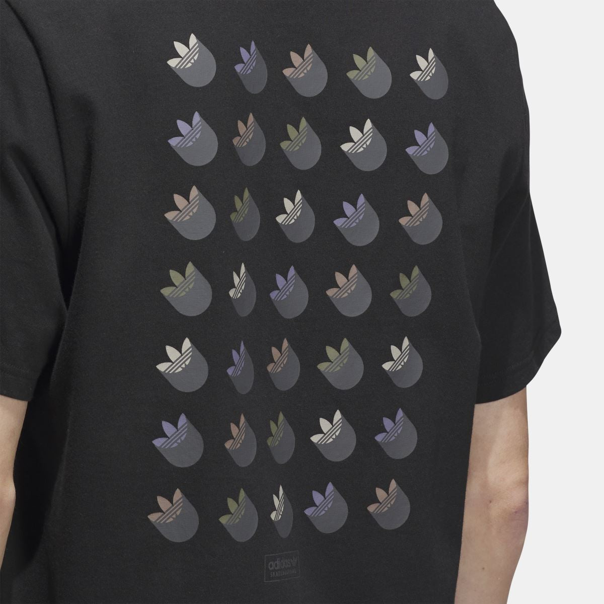 Black t-shirt close-up of trefoil shadow logo pattern on back