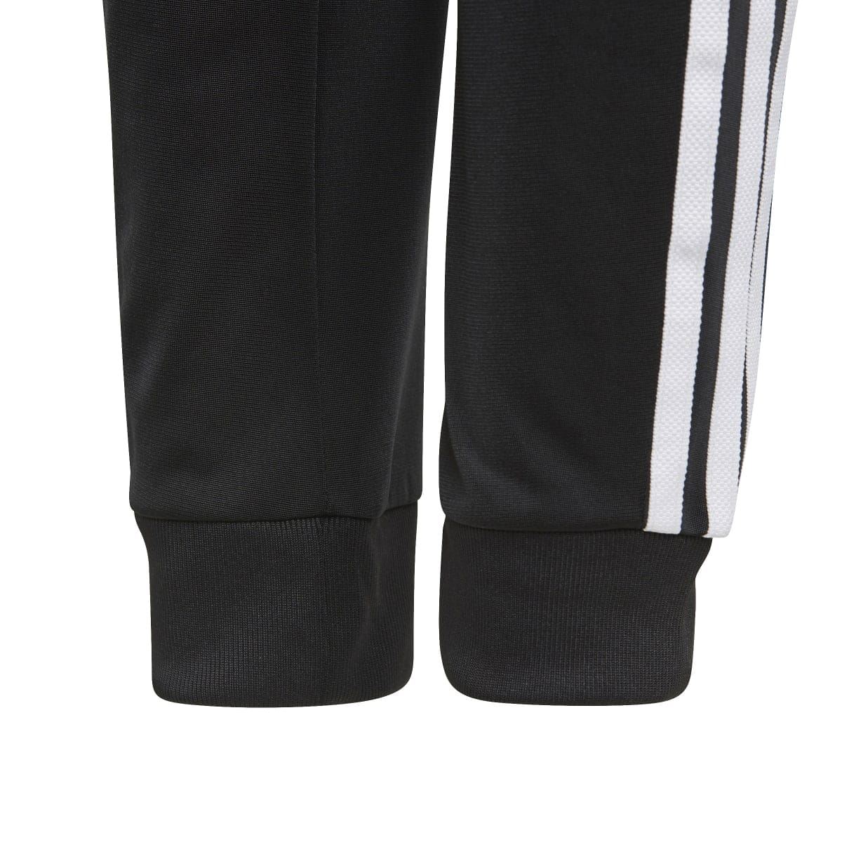 Black junior track pants with ribbed cuffs and white side stripes on lower legs