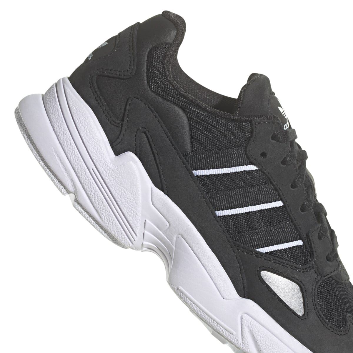 Black sneaker quarter view with stitched overlays and textured collar, side angle