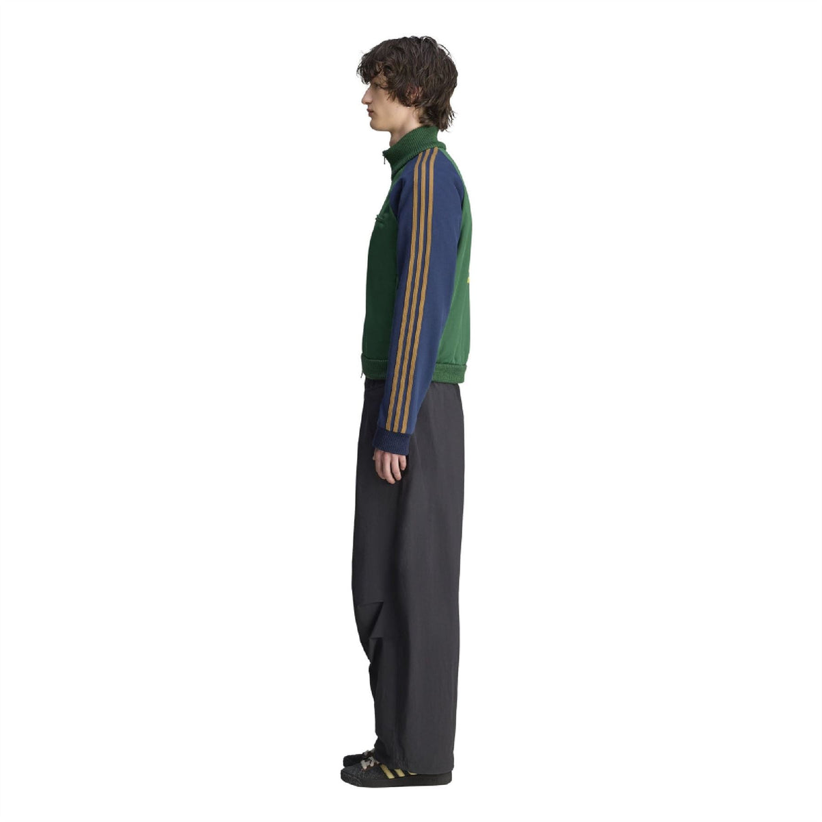 Green track top side view with navy sleeve panel and gold stripe detail