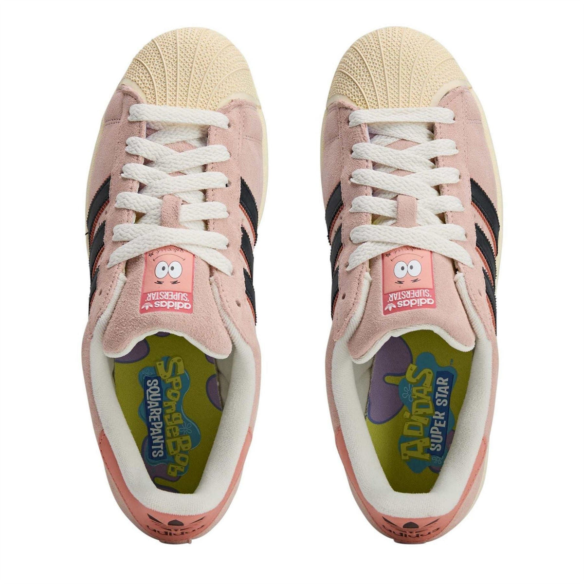 Pink sneakers with white laces and cartoon-lined tongue, lace-up front view