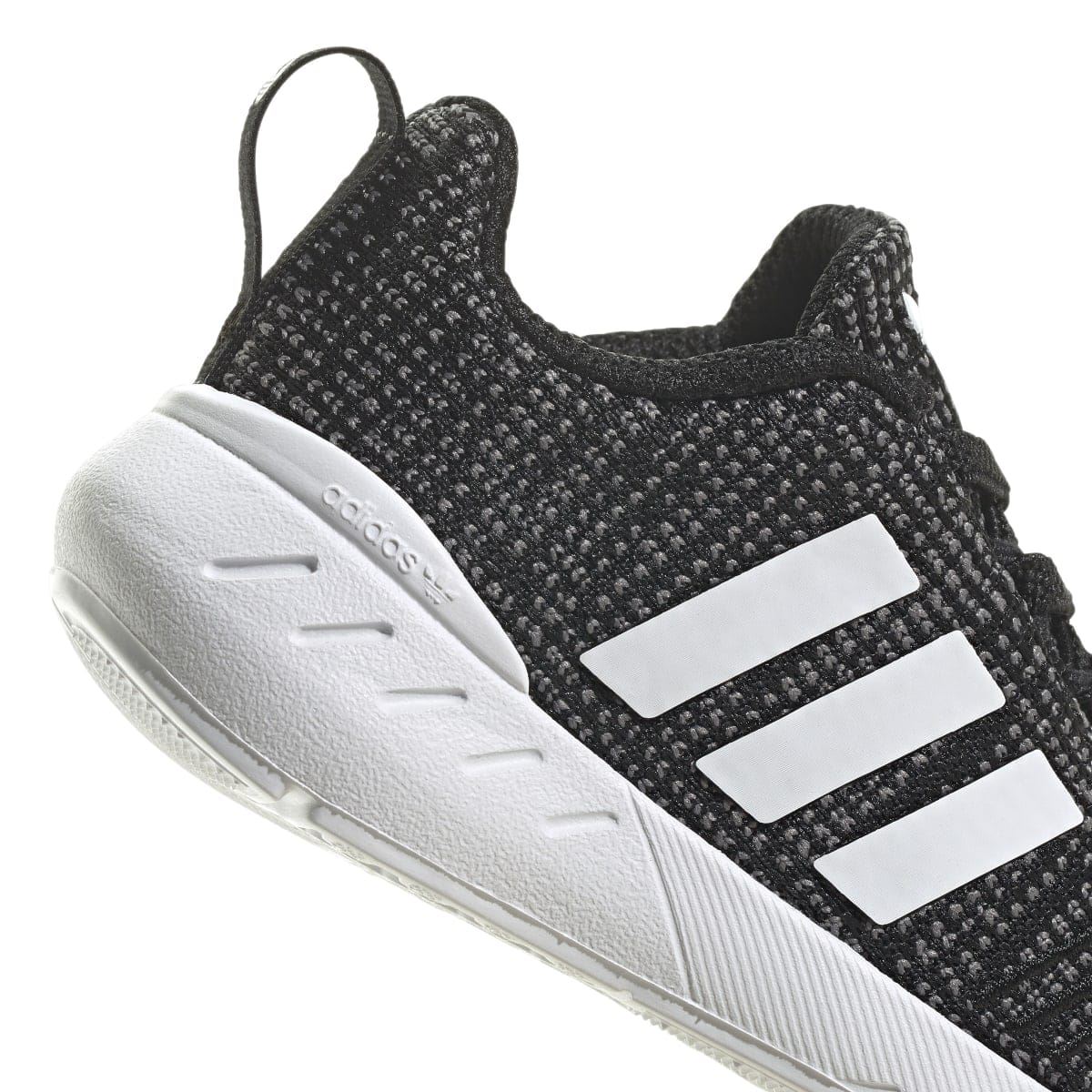 Infant black trainer close-up of side: white three stripes and cushioned white sole