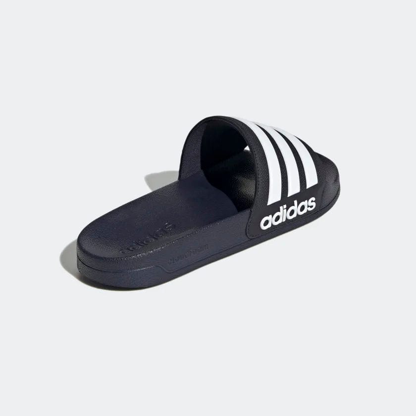 Navy shower slide sandals from side view with white triple stripes on the upper