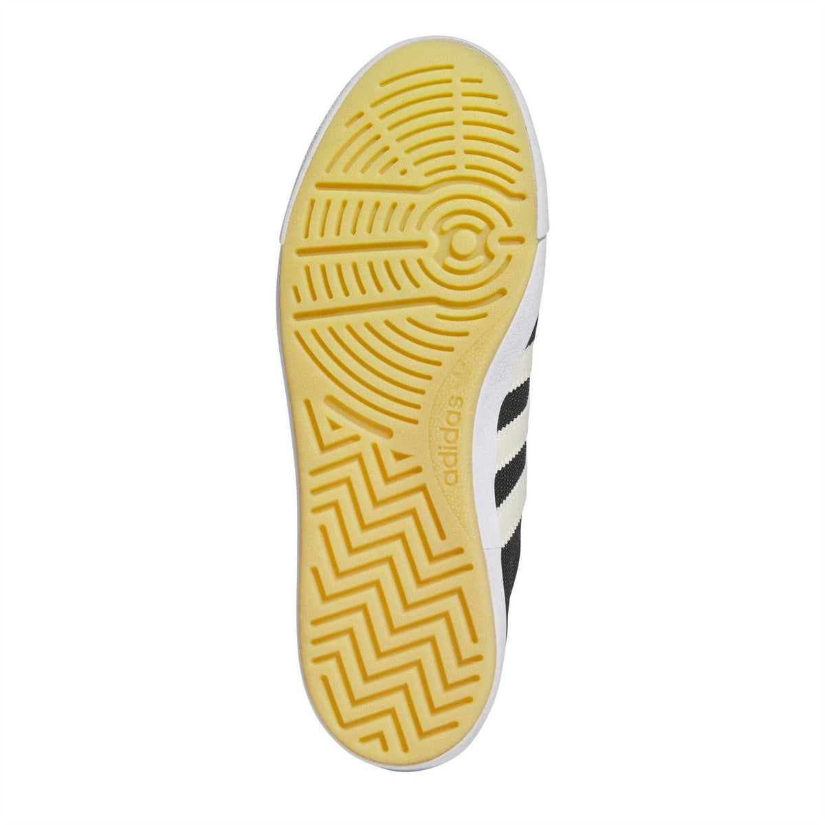 Outsole view of black adidas trainers with yellow gum-style rubber tread