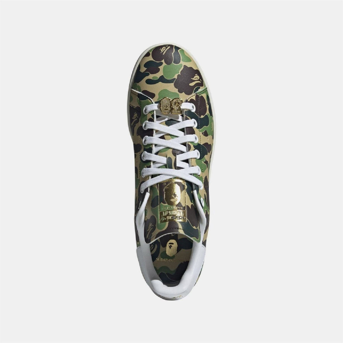 Stan Smith sneaker top view, green/brown camo upper, white laces and gold lace-lock