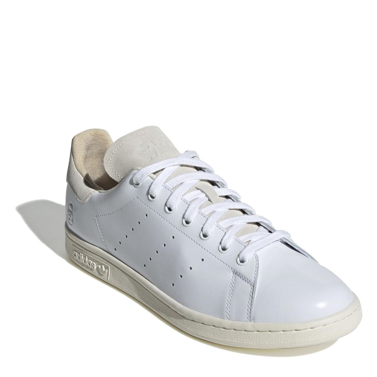 White leather-style sneakers with lace-up closure, beige lining, and heel tab