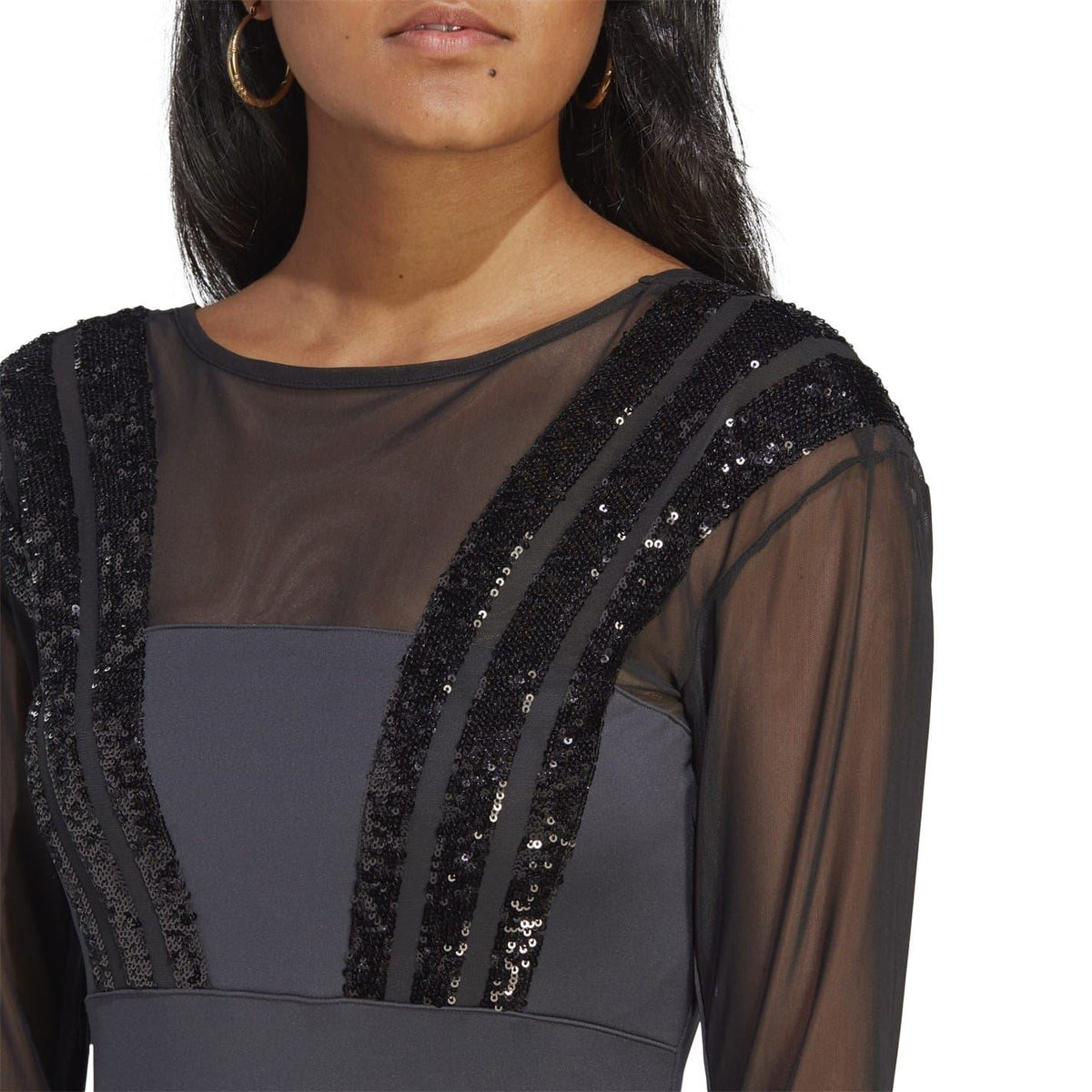 Black bodysuit close-up with crew neck, sheer sleeves, and sequin stripe front