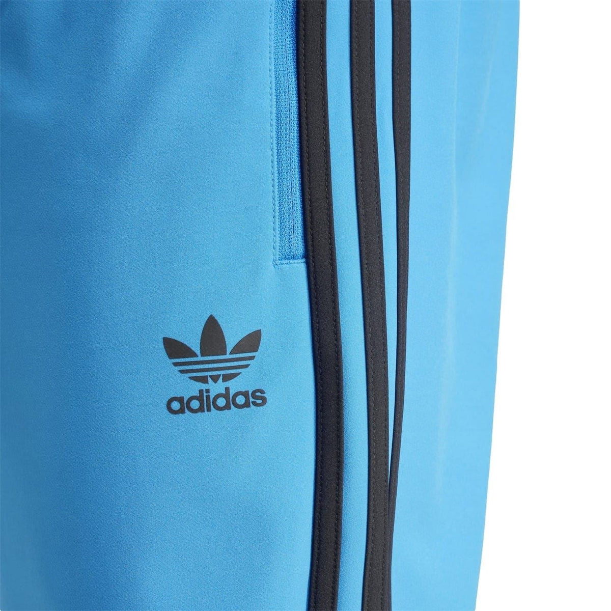 Blue slim track pants with adidas logo and vertical black stripe panel