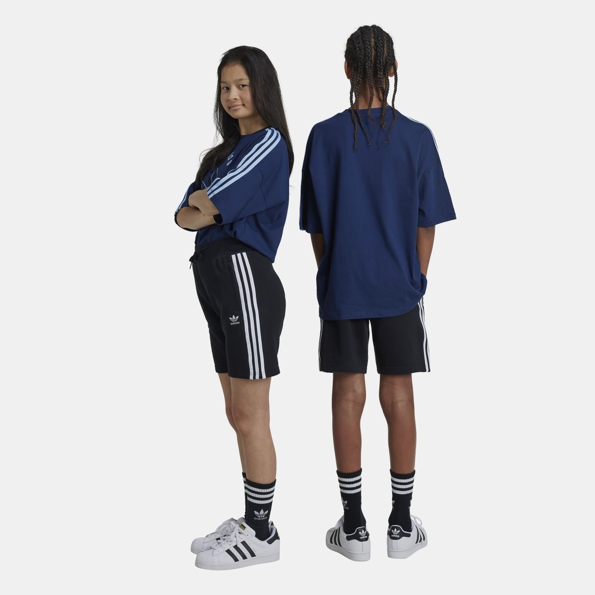 Light blue adidas Originals Juniors Adicolor Shorts for kids aged 8-16, featuring an elastic waistband and signature three stripes.