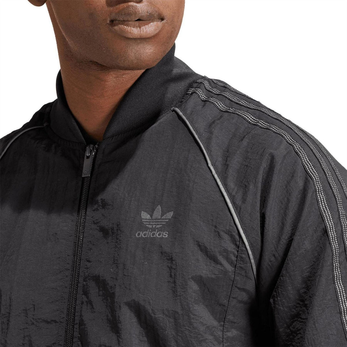 Black track jacket shoulder with adidas logo and stripe trim detail