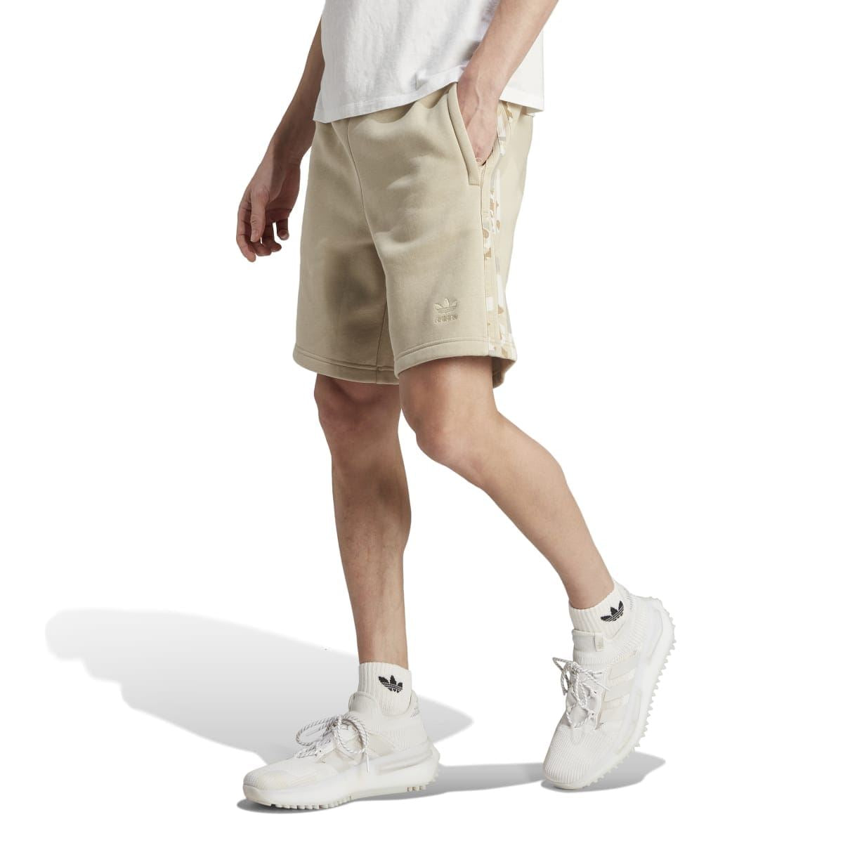 Sand graphic camo stripe shorts worn with sneakers, side seam stripe detail visible