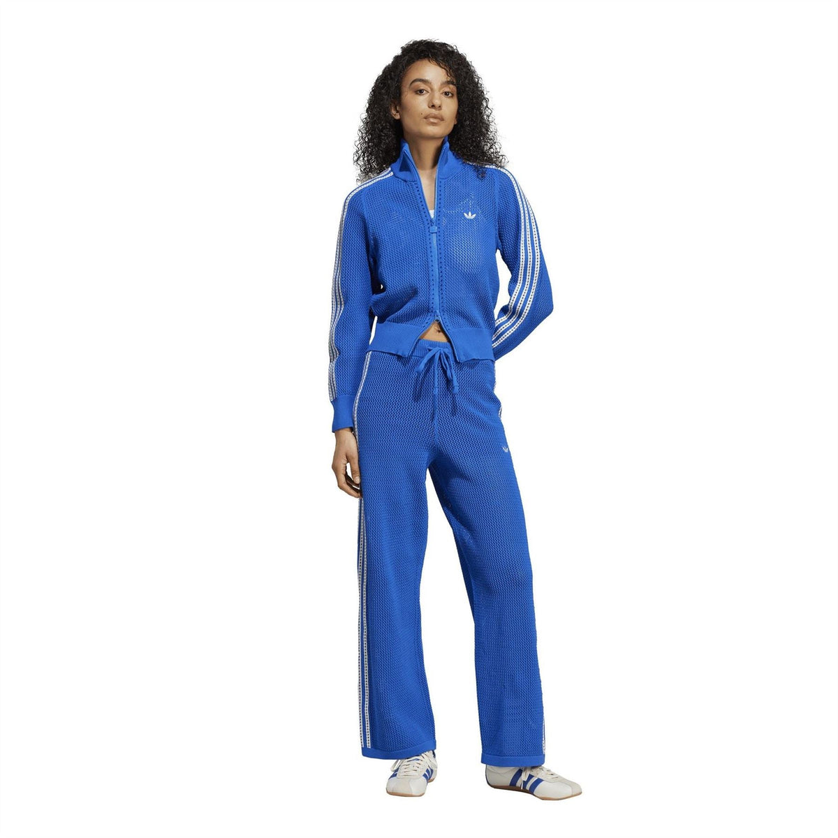 adidas Originals crochet track pants on model, blue wide-leg pants with side stripes
