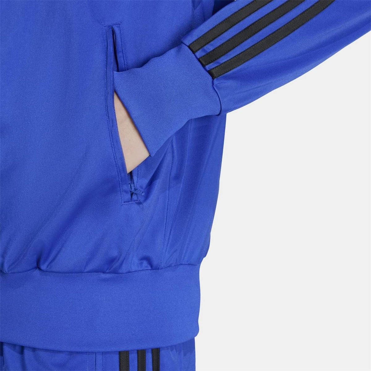 adidas Originals Classics Firebird Track Top in black with white stripes, displayed on a hanger against a neutral background.