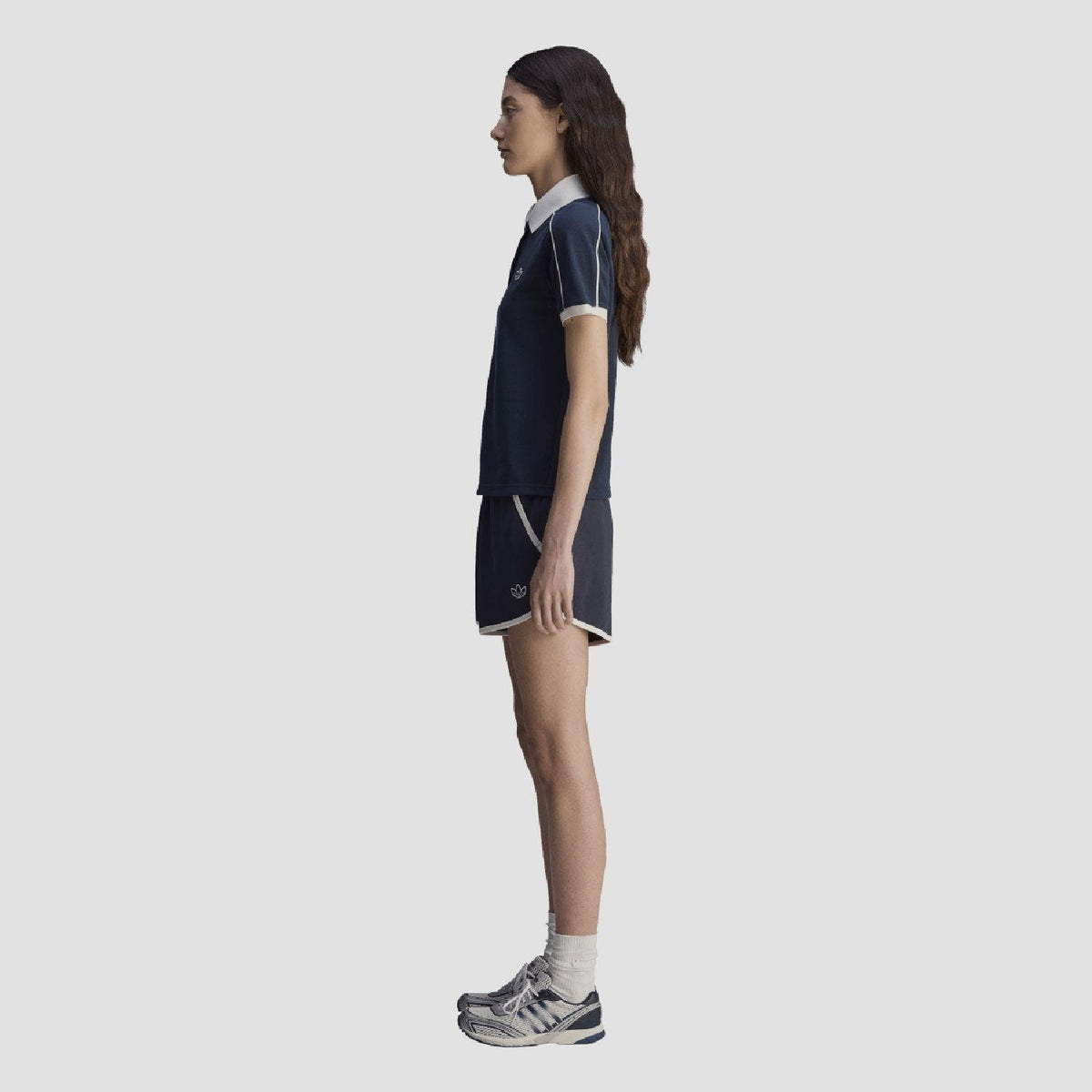 Navy polo shirt side view with white-trim sleeve edge and button placket
